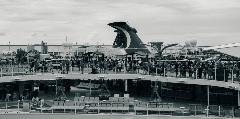 Black and white view of a busy cruise ship deck with passengers in The Bahamas.